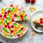 Gelatina de mosaico con cubos de colores rojo verde y amarillo en base blanca cremosa